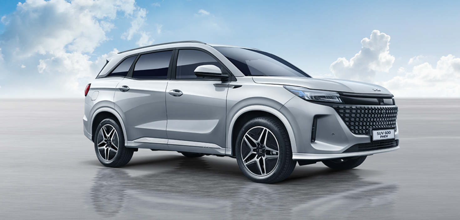 Vista lateral de Auto hibrido SUV 600 PHEV color gris con amanecer de fondo